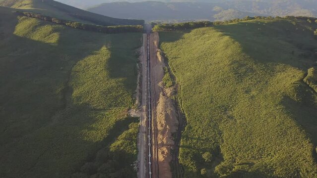 Laying the main gas pipe in a dug trench among the mountains