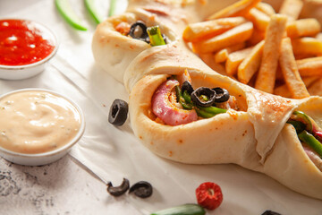 Chicken fajita stuffed bread naan with potato chips fries extreme closeup.