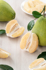 Fresh pomelo fruit on wooden table background.