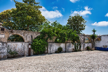 Fototapeta na wymiar Óbidos is one of the most beautiful and picturesque towns in Portugal, which is surrounded by its impressive walls and dominated by its imposing castle
