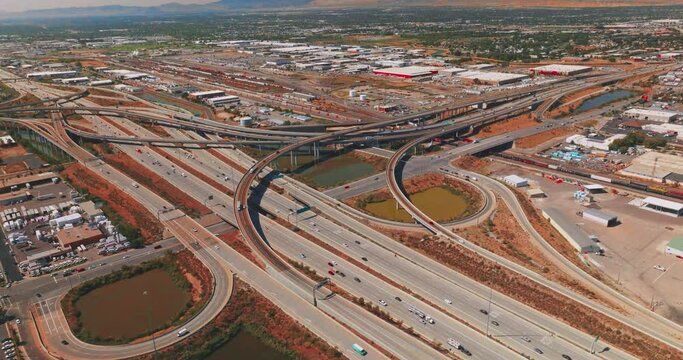 Highways and skyways with multiple cars moving by. Vast panorama of Salt Lake City on sunny bright day. Aerial perspective.