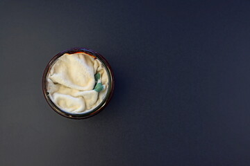 Mold in a round glass jar on a gray background. Mold spores on preserves. Spoiled jam. Poisonous fungus.