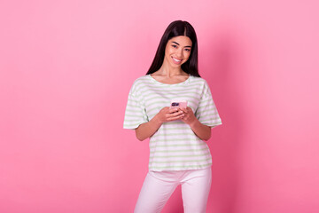 Photo portrait of stunning young korean lady arms hold telephone share read news wear trendy white outfit isolated on pink color background