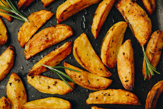 Roasted potatoes. Baked potato wedges with rosemary. Top view.