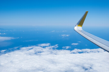 airplane wing flying over the blue sky
