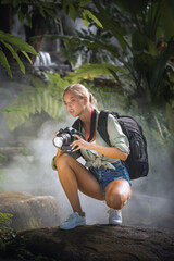 portrait of nice young woman is taking picture in the jungle