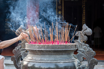 Ofrendario budista lleno de sahumerios e incienso puesto por debotos y creyentes