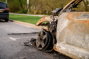 Wreck of burned car on the side of the road