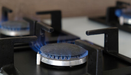 Obraz na płótnie Canvas Close-up blue flames of fire on a gas burner in the kitchen for cooking. Gas flame in a gas boiler