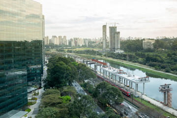Fototapeta premium Beautiful view of São Paulo city skyline, modern buildings, Marginal Pinheiros avenue and river. Corporate towers and viaduct under construction. Concept of cityscape, urban, travel, architecture.