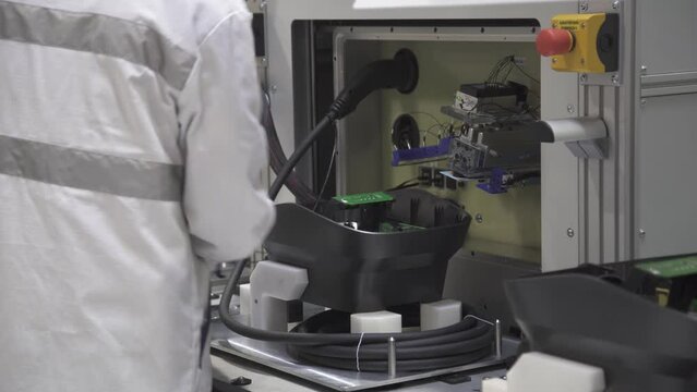 Worker testing product on assembly line. Conveyor work