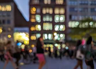 Blurred lights of a busy New York City street scene at night with crowds of people walking