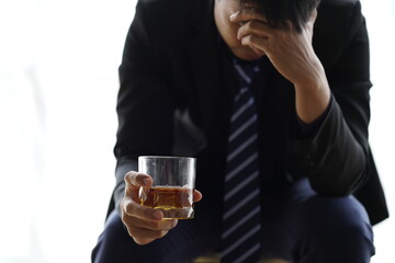 Businessman handshake after make deal, alcoholism, alcohol addiction and people concept - male alcoholic with glass of whiskey lying or sleeping on table 