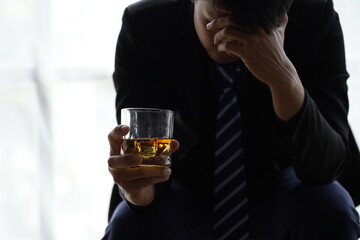 Businessman handshake after make deal, alcoholism, alcohol addiction and people concept - male alcoholic with glass of whiskey lying or sleeping on table 
