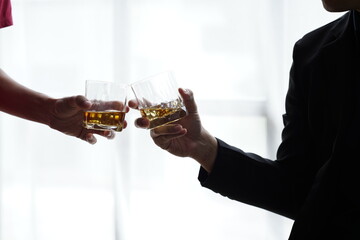 Businessman handshake after make deal, alcoholism, alcohol addiction and people concept - male alcoholic with glass of whiskey lying or sleeping on table 