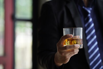 Businessman handshake after make deal, alcoholism, alcohol addiction and people concept - male alcoholic with glass of whiskey lying or sleeping on table 