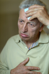 Elderly man wipes sweat with a handkerchief 