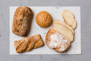 Freshly baked bread slices on napkin against natural background. top view Sliced bread