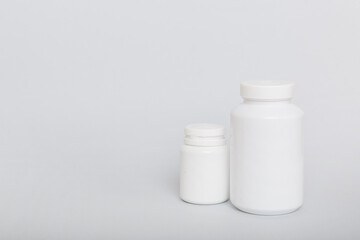 supplement pills with medicine bottle health care and medical top view. Vitamin tablets. Top view mockup bottle for pills and vitamins with green leaves, natural organic bio supplement, copy space