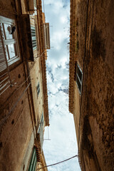 Tropea old town view - narrow street, architecture and cloudy sky. Travel vacation in Calabria, southern Italy. - obrazy, fototapety, plakaty