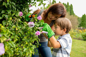 Mom and son taking care of plants in family garden