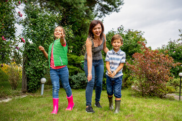 Mom with her children seeding grass in their family garden