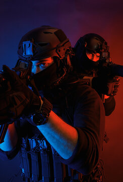 Attentive male warriors with rifles aiming in dark room