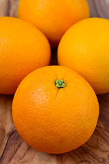 Four whole Oranges on a wood background
