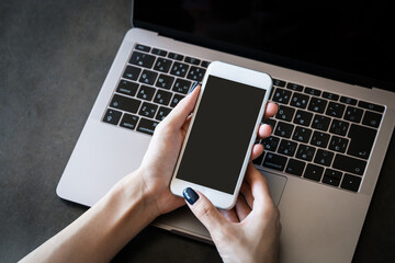 オフィスでスマホを操作する女性の手元
