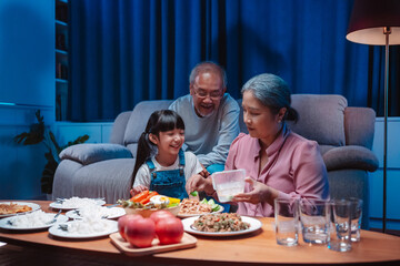 Asian happy family having lunch on dinner japanese table smiling together. little kid daughter enjoy eating food grandparents. Happiness time people lifestyle concept.