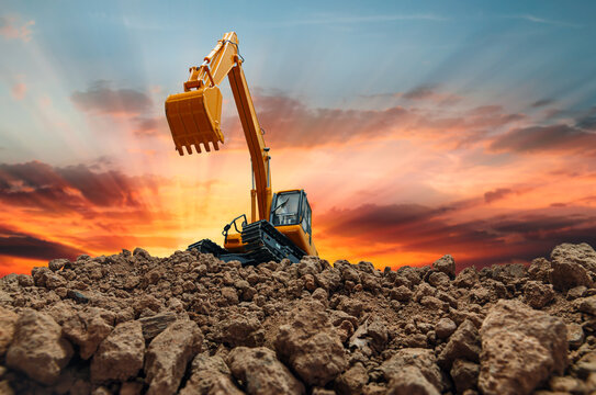 Crawler Excavator is digging with lift up in the construction site  on sunset white background.