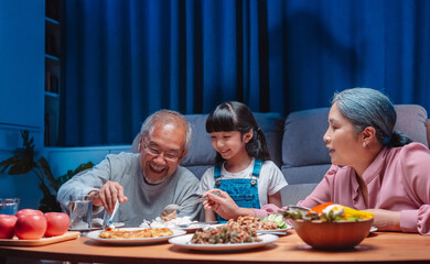 Asian happy family having lunch on dinner japanese table smiling together. little kid daughter enjoy eating food grandparents. Happiness time people lifestyle concept.