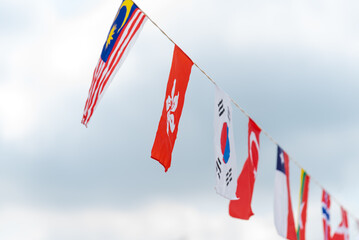 Countries' flag banners hanging on a rope line for festivals. 