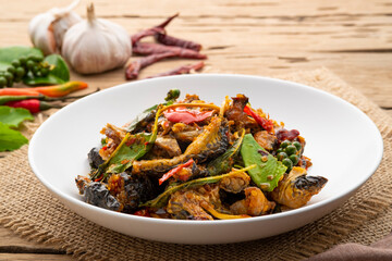 Spicy Stir Fried Frog meat with chilli paste and basil leave on white plate