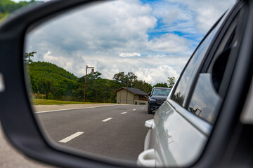 Beautiful view of blue sky and white clouds from car rearview mirror