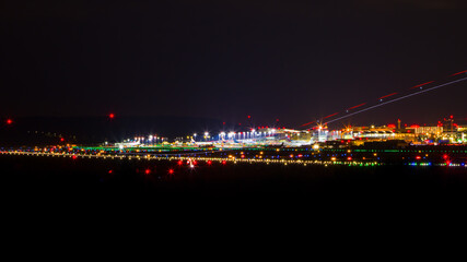 Fototapeta na wymiar Flughafen Stuttgart bei Nacht mit Lichtspur von landendem Flugzeug