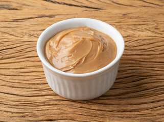 Doce de leite, traditional brazilian creamy milk sweet over wooden table