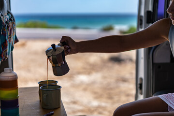 Young woman makes a coffe for breakfast in his campervan