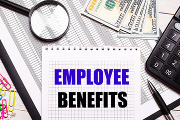 On the office table there is a notebook with the text EMPLOYEE BENEFITS, a pen, a calculator,...