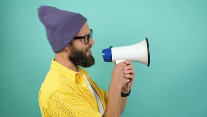 Funny emotional guy with megaphone, talking proclaiming news, loudly announcing advertisement, hot news announce discounts sale hurry up communication concept. Studio video isolated on blue background