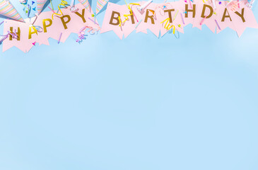 Birthday greeting card simple background. Garland streamer with the inscription HAPPY BIRTHDAY on a blue background, with accessories for celebration holiday, banner background copy space flatlay