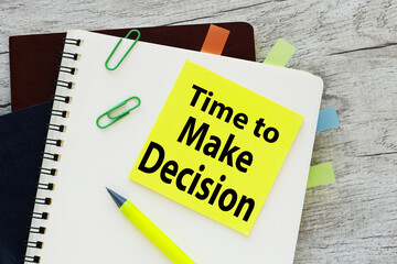 notepad with text time to make a decision on a wooden background. sticker text