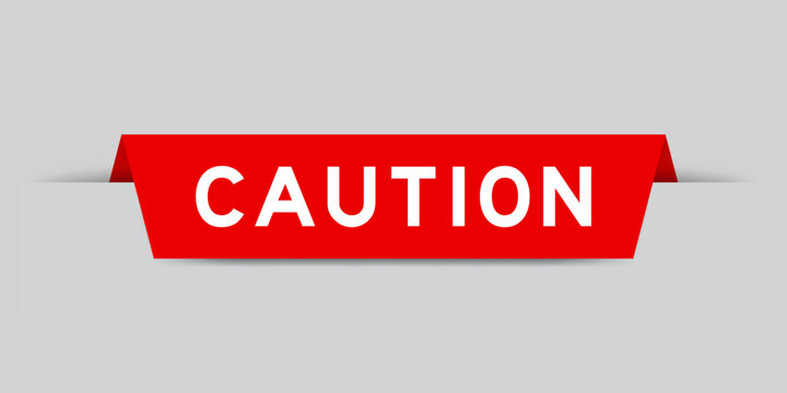 Red color inserted label with word caution on gray background