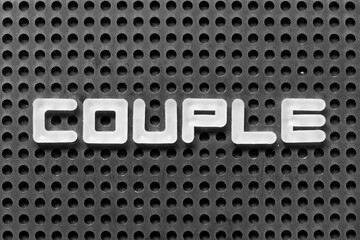 White alphabet letter in word couple on black pegboard background