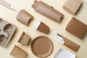 Top view of a flat bed. eco-friendly paper utensils and packaging on a yellow background. The concept of using biodegradable materials to replace plastic.