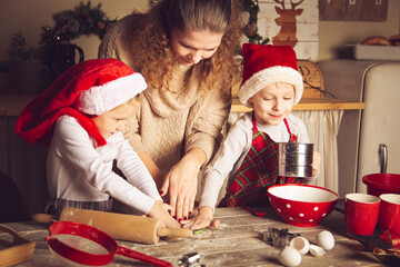 Mom and children are preparing cookies in the kitchen.