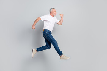 Fototapeta na wymiar Full length body size view of attractive cheerful sportive man jumping running fast isolated over grey pastel color background