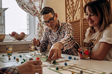 A group of young people play board games at home in the kitchen.Time together.Stay home,board games...
