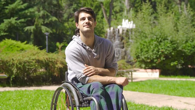 Happy physically disabled young man on the street, in the park.
Disabled person traveling in a wheelchair in a nature park.
