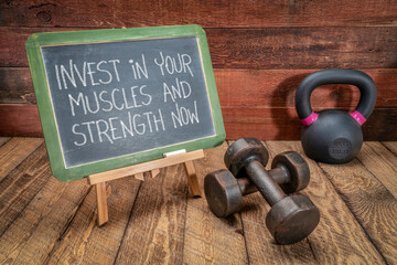 invest in your muscles and strength nowinvest in your muscles and strength now - motivational text on a blackboard with dumbbells and kettlebell, health and fitness concept
